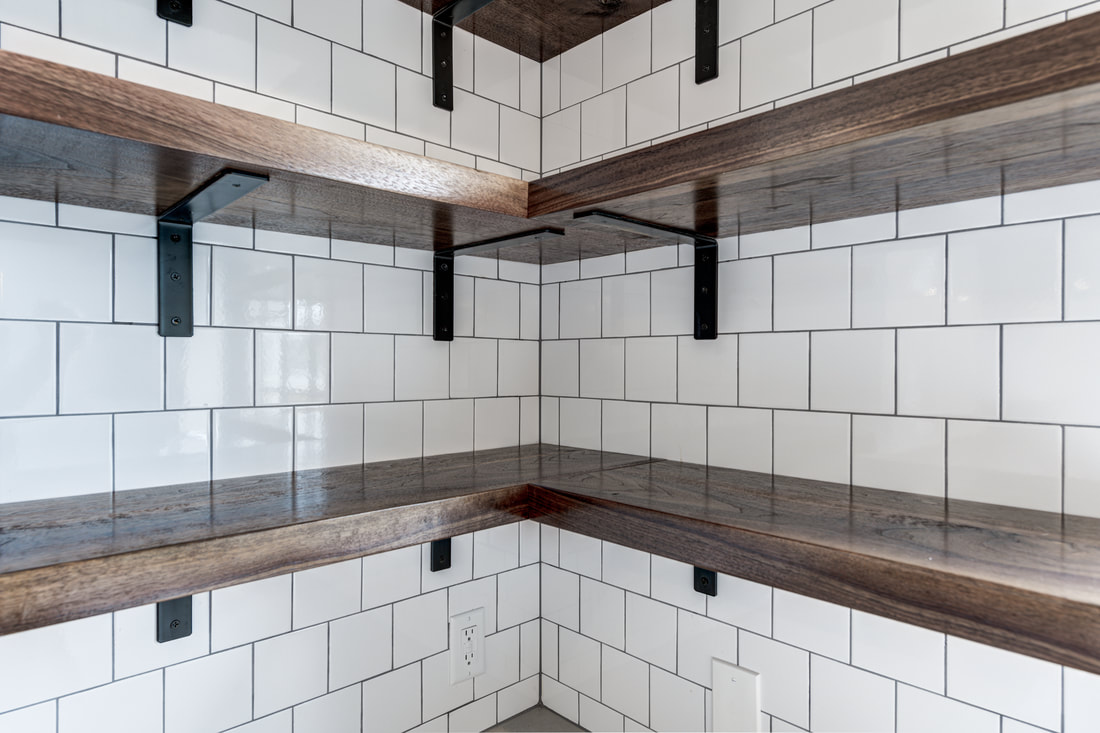 Close-up of dark wood floating shelves with black metal brackets