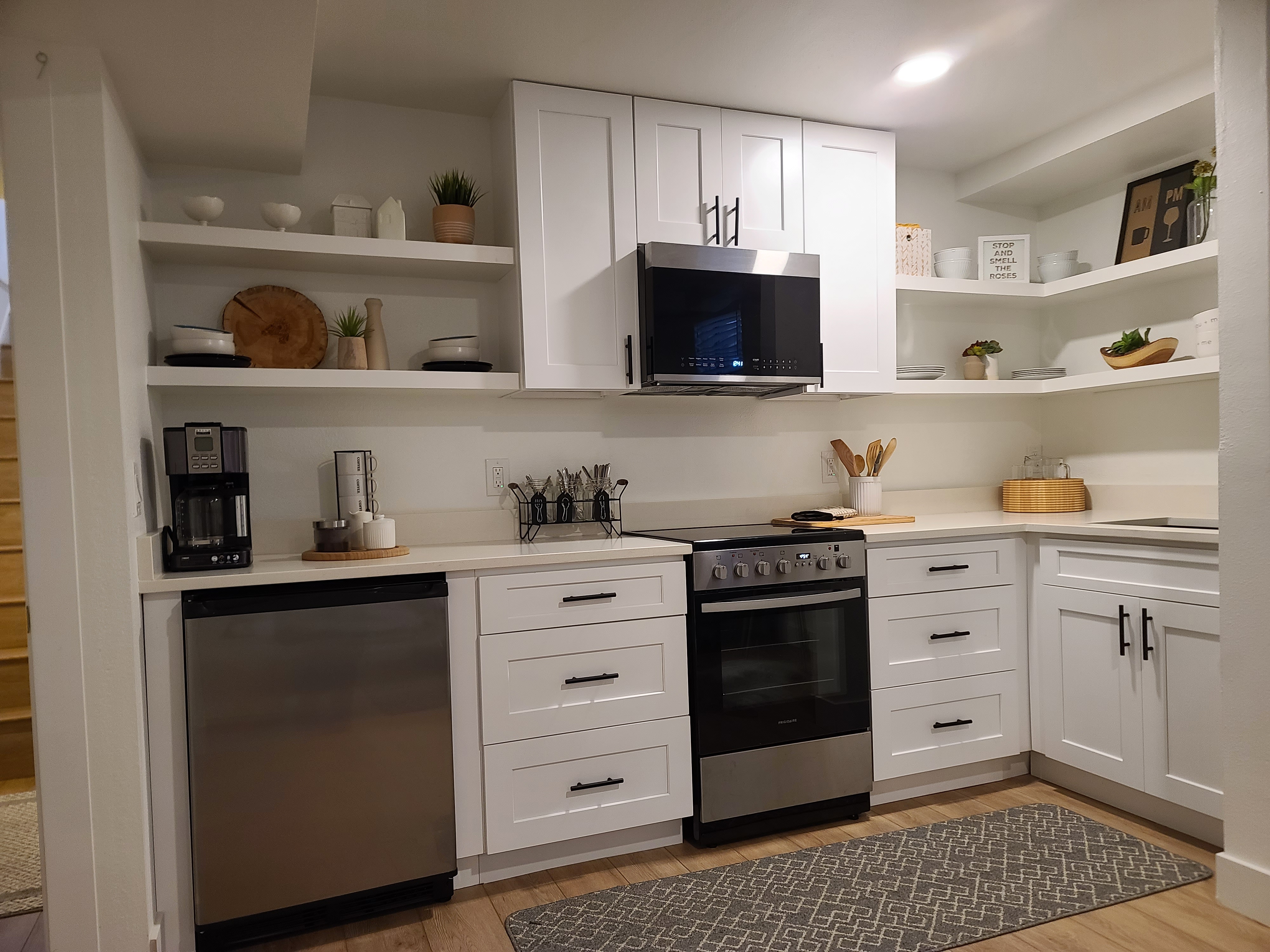 Built-in kitchenette with custom cabinetry and open shelving