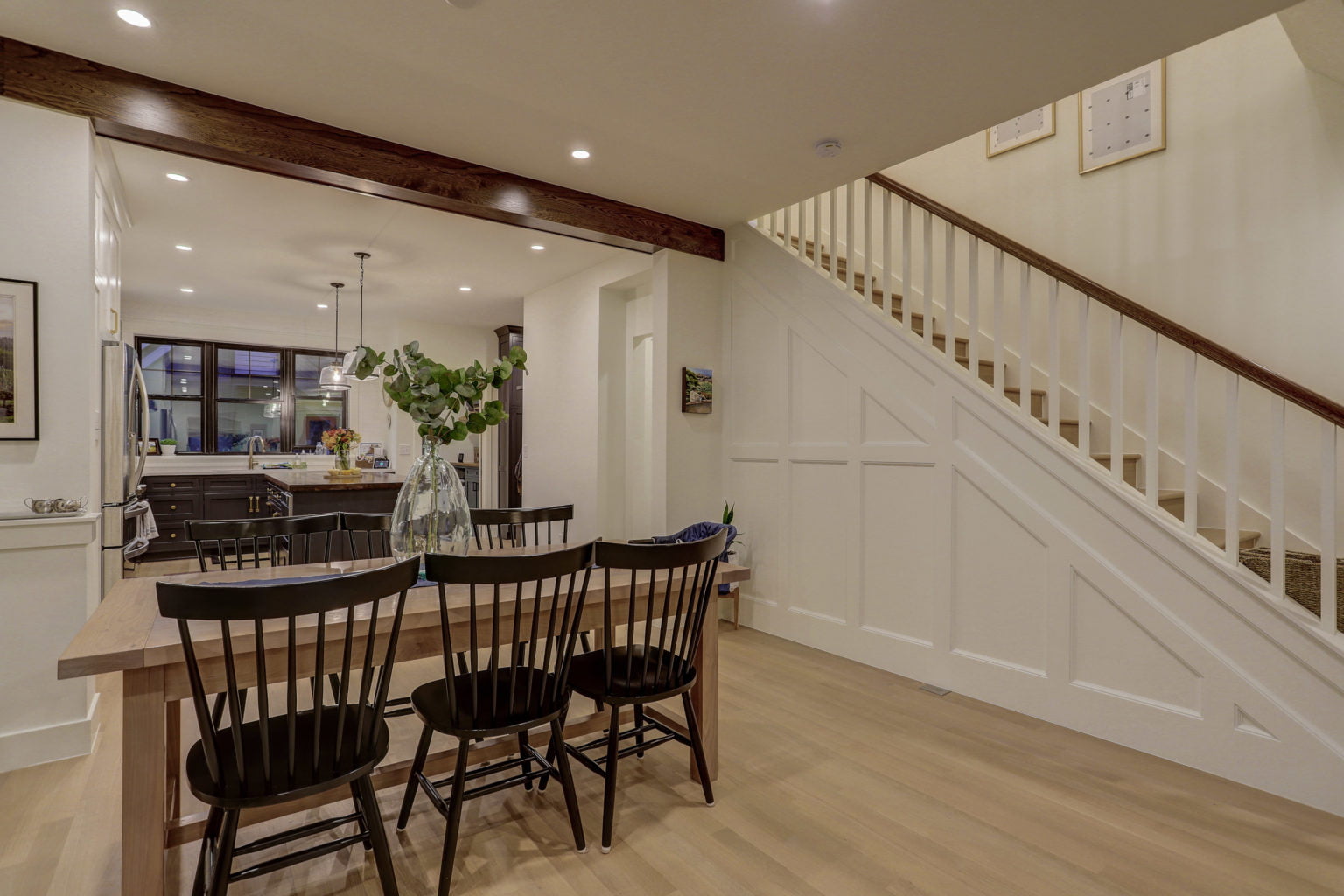 Dining area with board-and-batten wainscoting under staircase