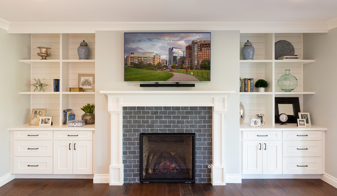 Custom built-in shelving and cabinets flanking a fireplace