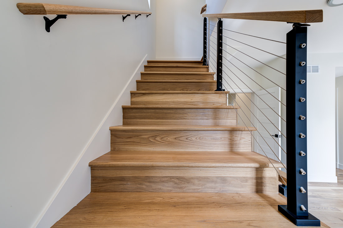 Modern oak staircase with cable railing and black steel post