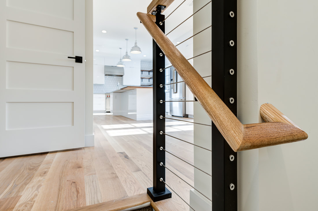 Cable railing newel post detail with oak handrail