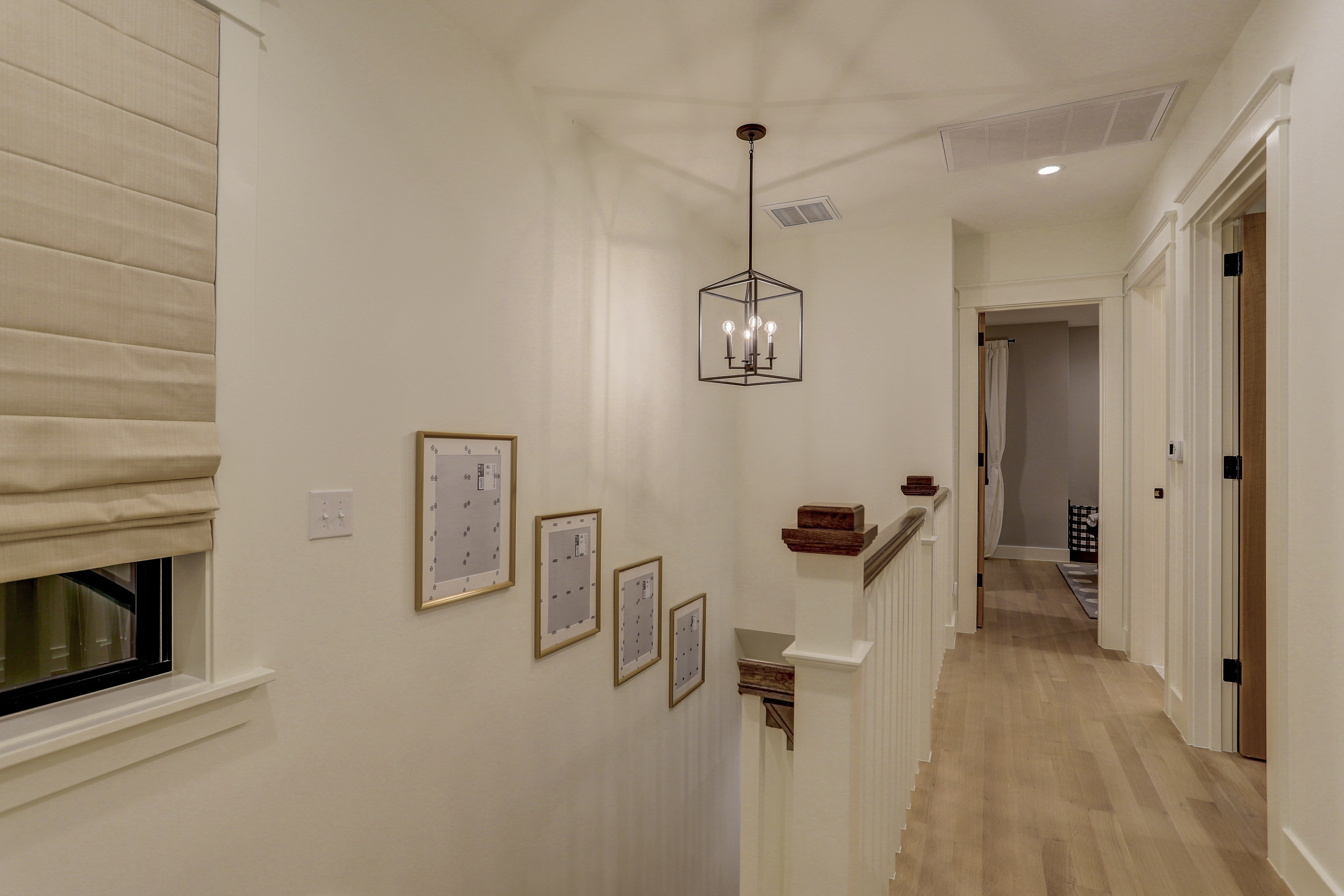 Upstairs landing with crown moulding, trim work, and pendant lighting
